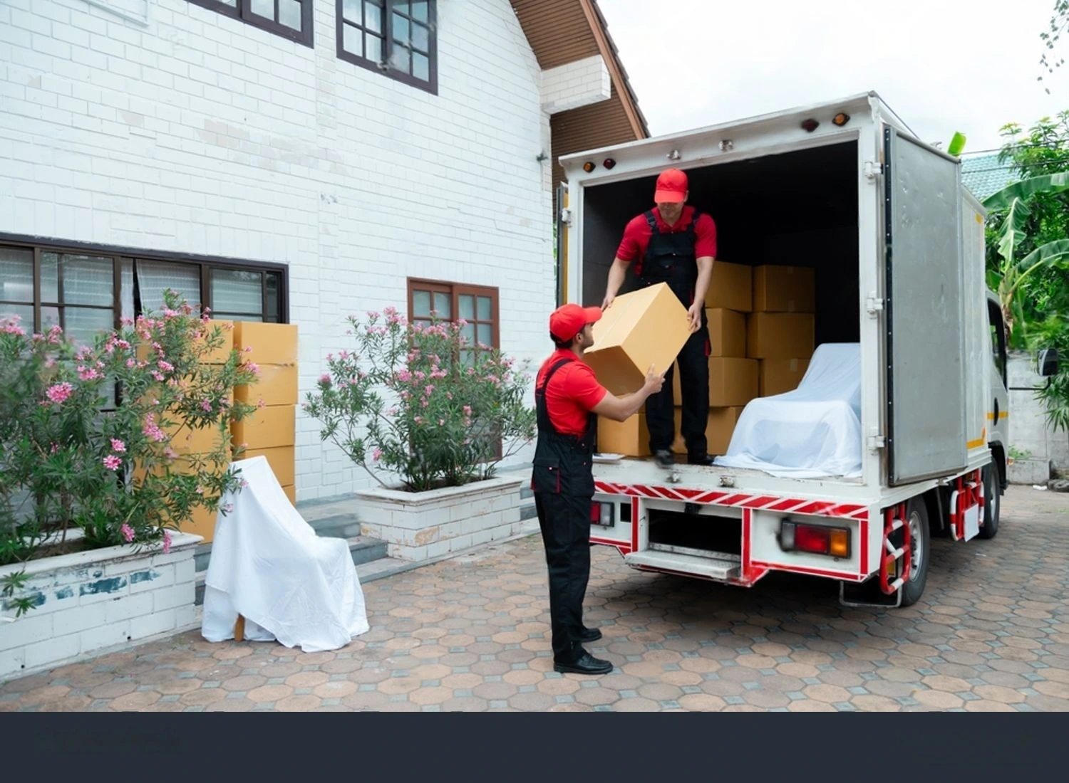 Furniture movers in Abu Dhabi carrying wrapped furniture