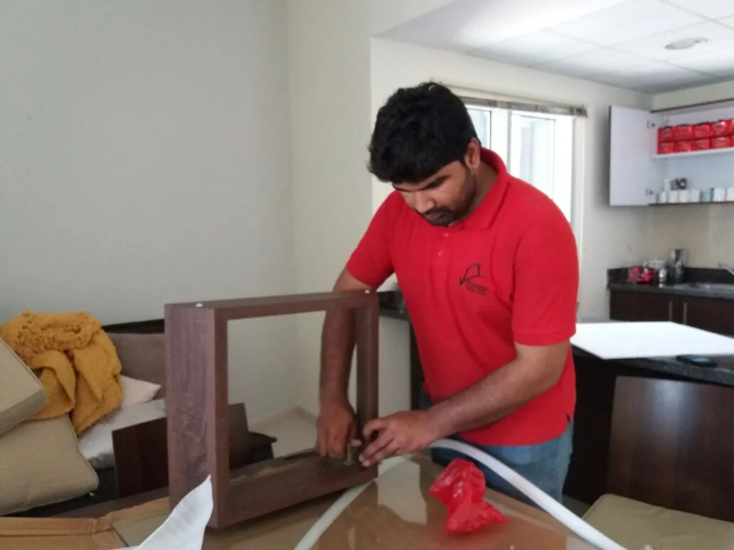 Expert Furniture Movers crew member assembling wooden furniture during a home move in Abu Dhabi