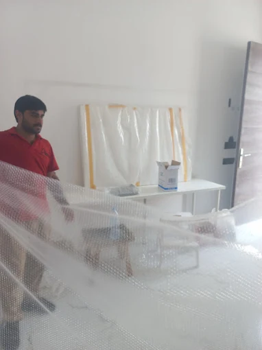 Expert Furniture Movers team wrapping furniture in bubble wrap during a Zayed City move